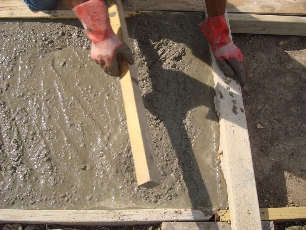 Concrete flatwork being screeded and finished